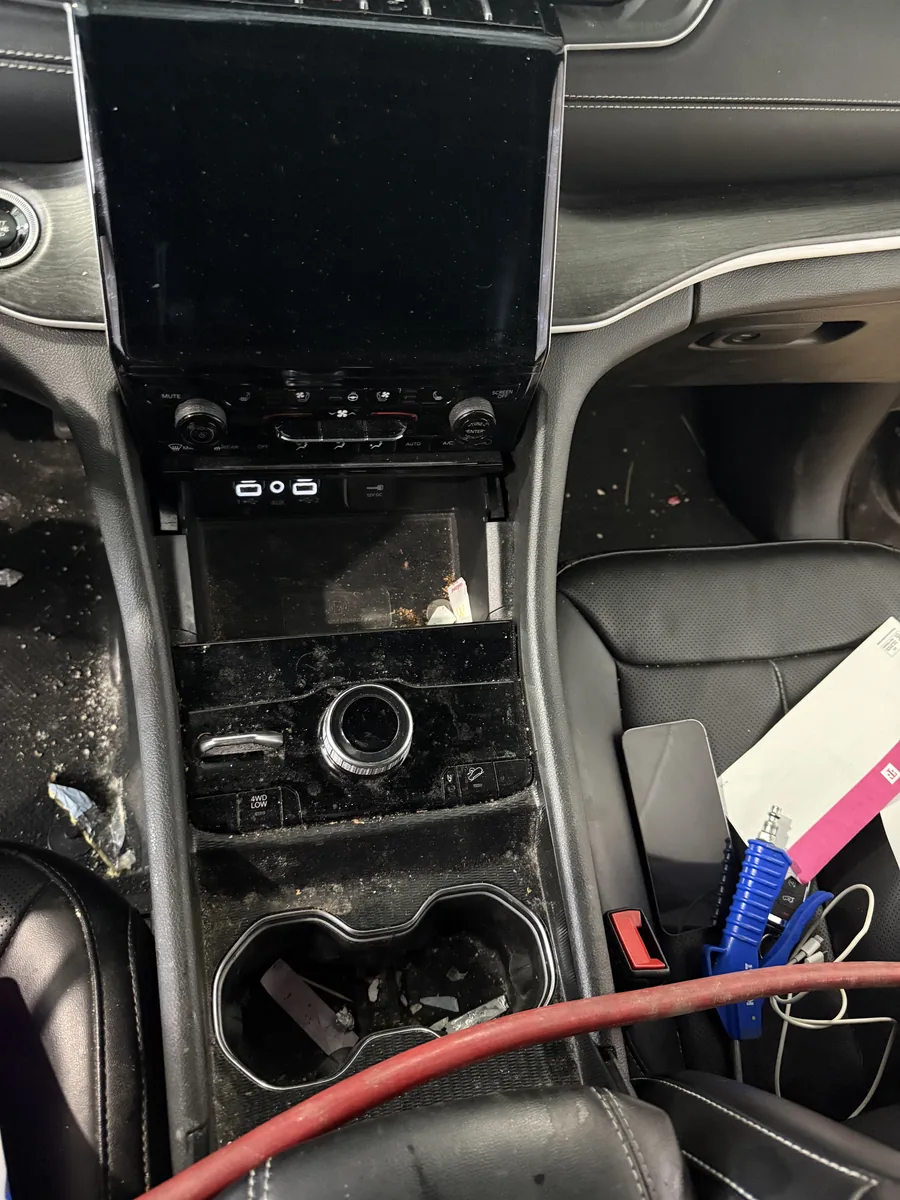 Center console at check-in, heavy dust and debris in the cup holders
