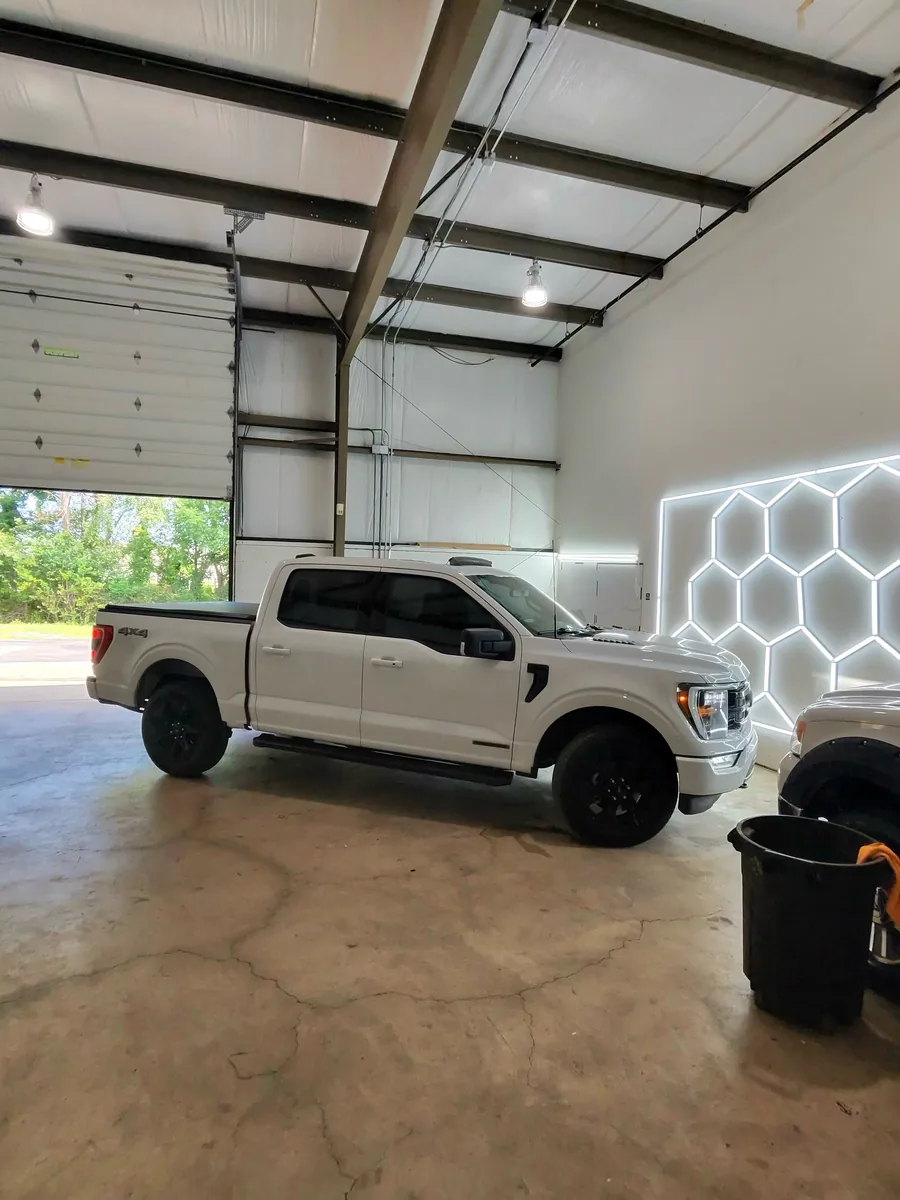 White Ford F-150 in the shop under the hex lighting
